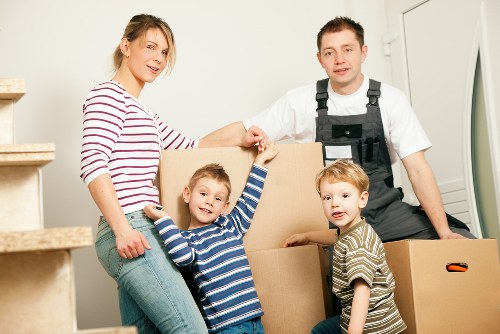 Removal workers carrying furniture down stairs in a North London flat